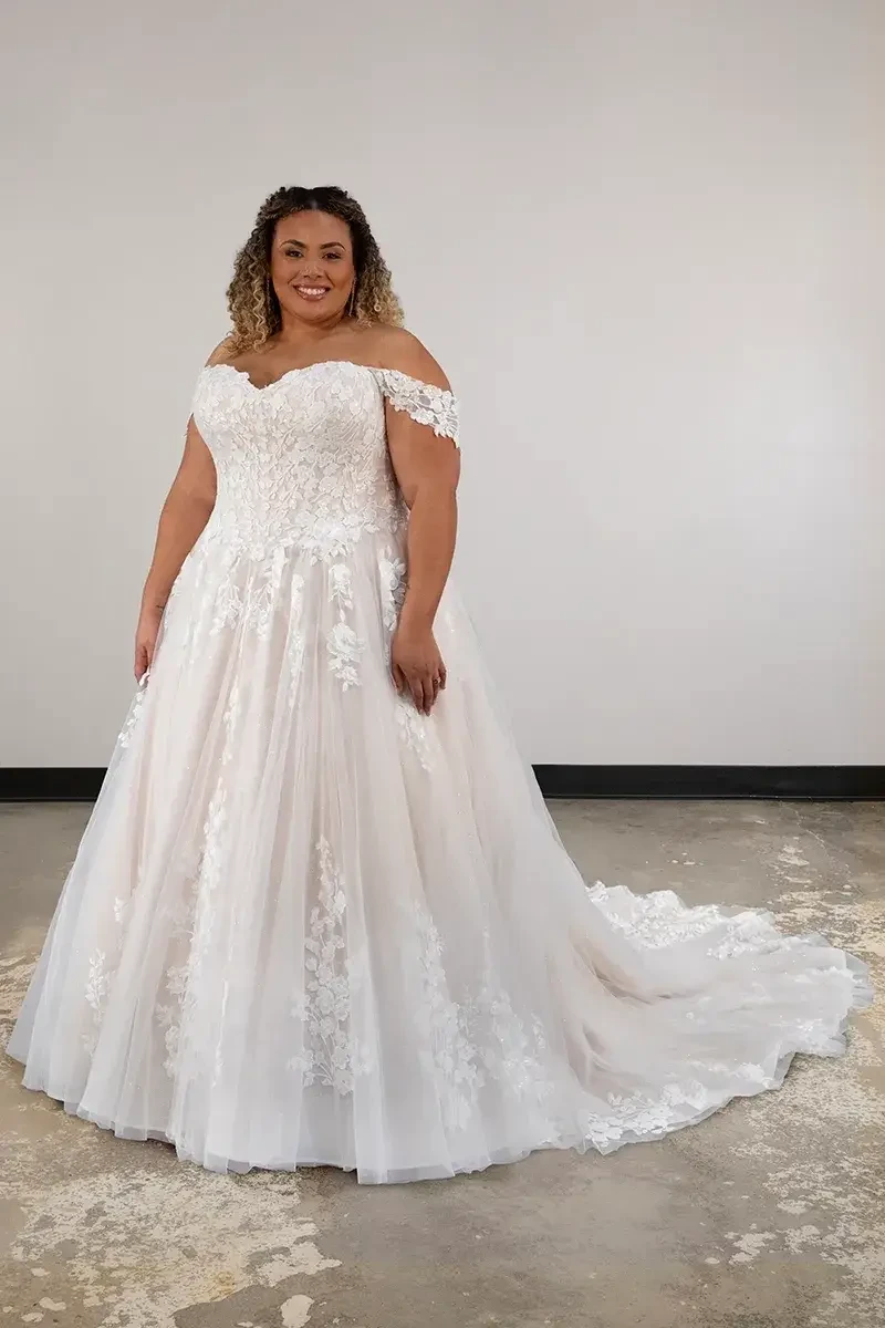 model is wearing an off the shoulder lace wedding dress