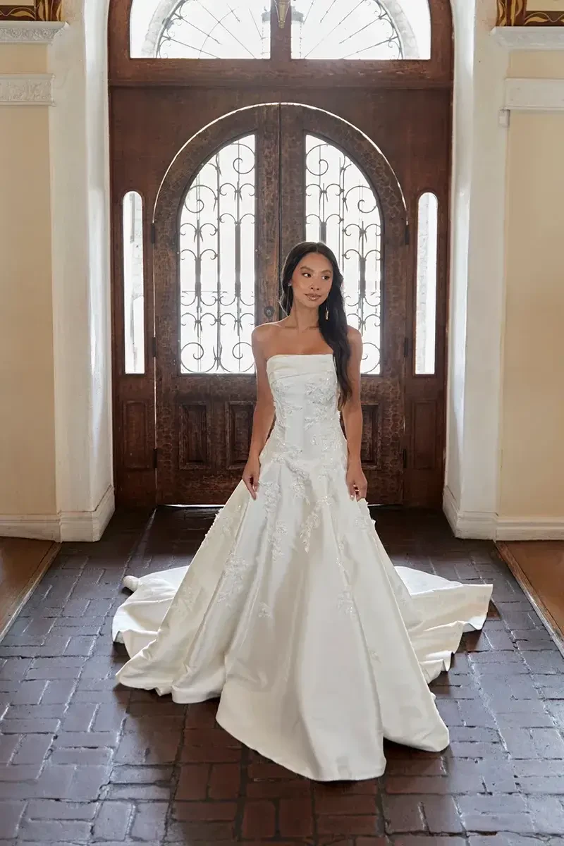 model is wearing a strapless fit and flare wedding dress 